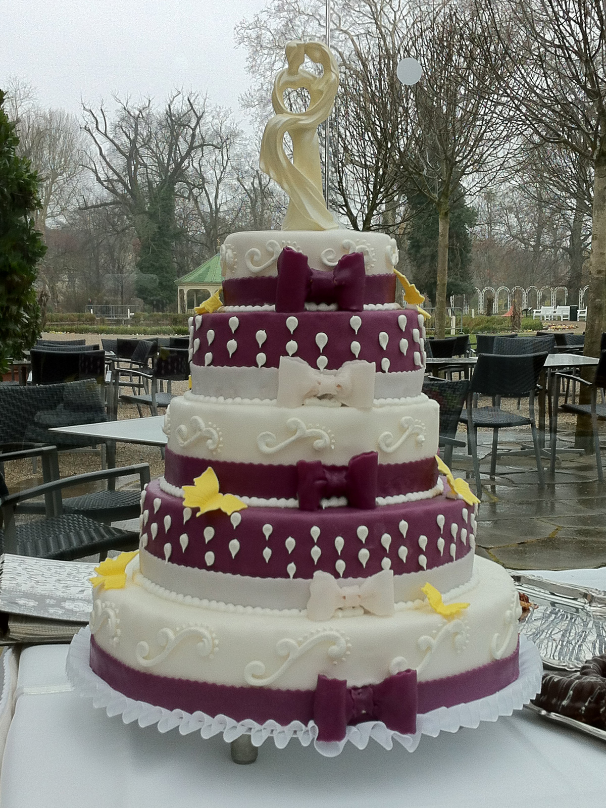 Hochzeitstorte dreistöckig, weiss mit weinroten Bordüren, Schleifen und Schmetterlinge